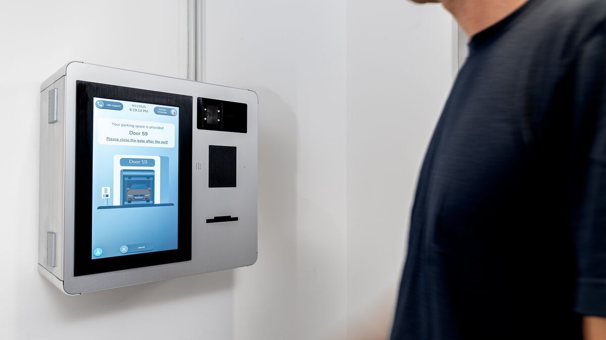 A person operates the control terminal of the WÖHR Combilift 542/543 to manage the parking process.