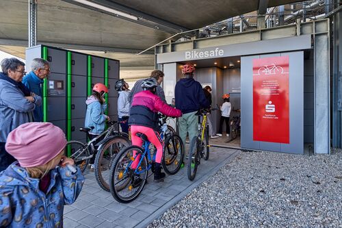 Niños con bicicletas frente a la entrada del sistema automático de aparcamiento de bicicletas