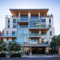 Moderno edificio residencial con acceso integrado al sistema de aparcamiento, amplios balcones y arquitectura de alta calidad.