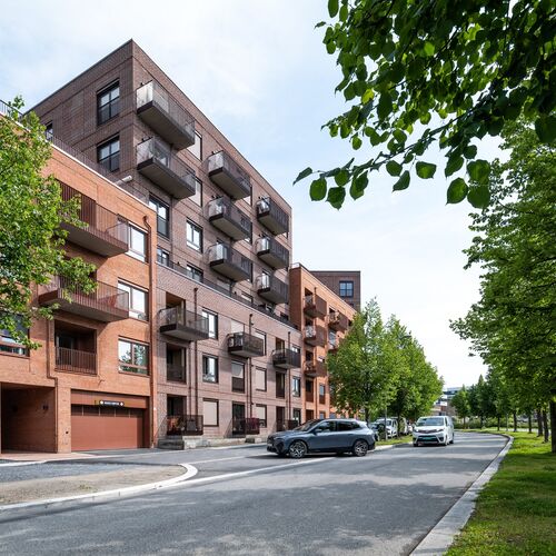 Modern residential development where a vehicle drives into a garage equipped with an integrated parking system.