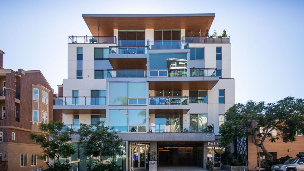 Moderno edificio residencial con acceso integrado al sistema de aparcamiento, amplios balcones y arquitectura de alta calidad.