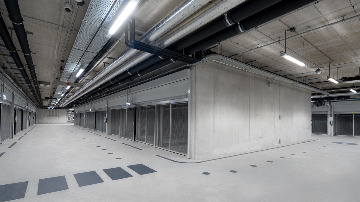Modern underground parking garage with an intersection area, continuous driving lanes, and parking systems arranged on both sides.