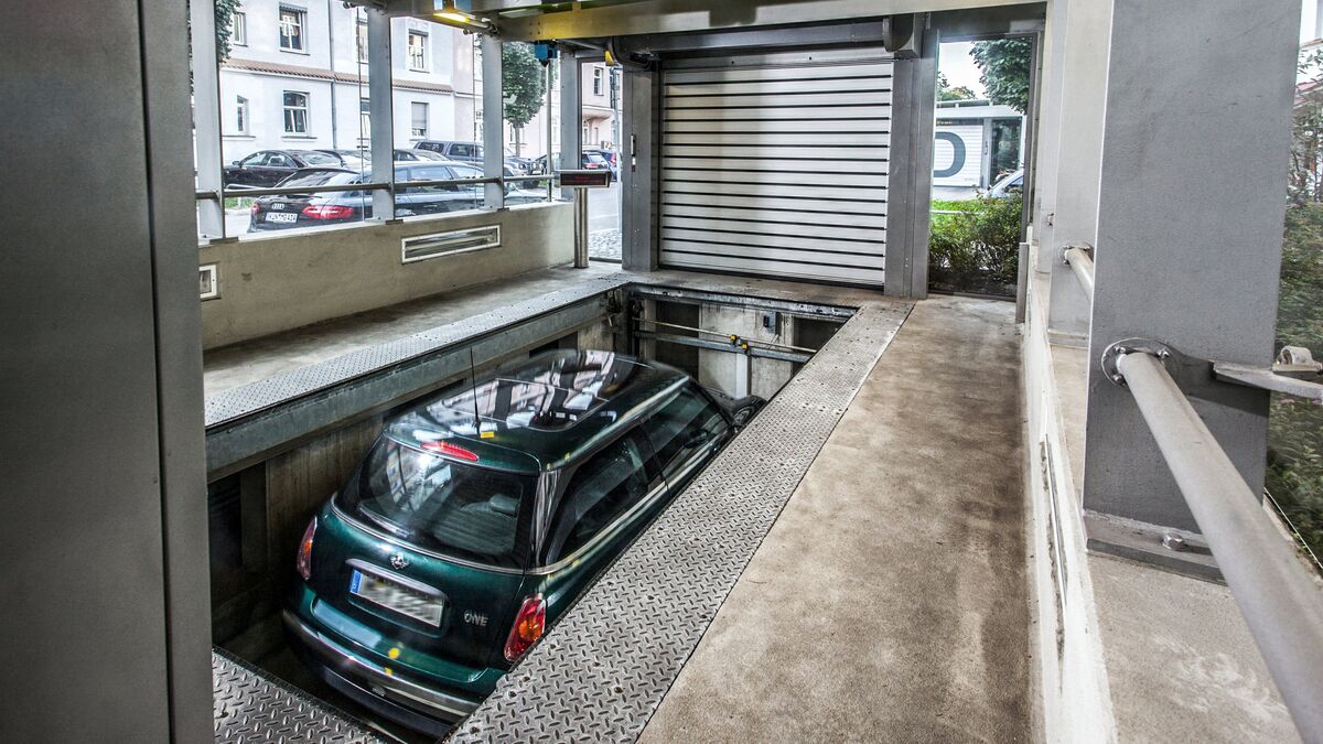 El coche se encuentra en una cabina de entrada sobre una plataforma de aparcamiento y desciende