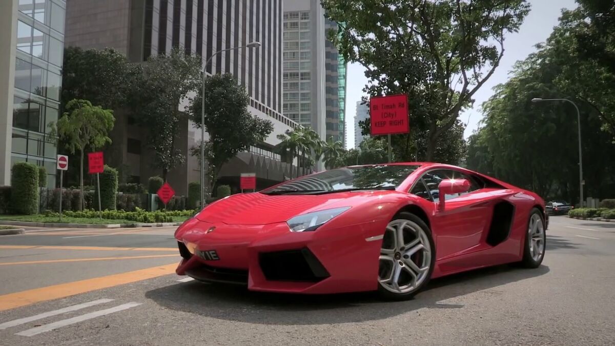 Un Ferrari rojo que entra en el aparcamiento subterráneo desde la calle