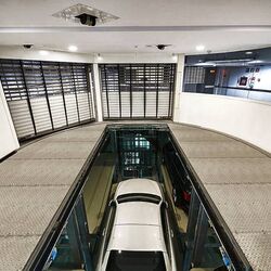 El coche se encuentra en una cabina de entrada sobre una plataforma de aparcamiento y desciende