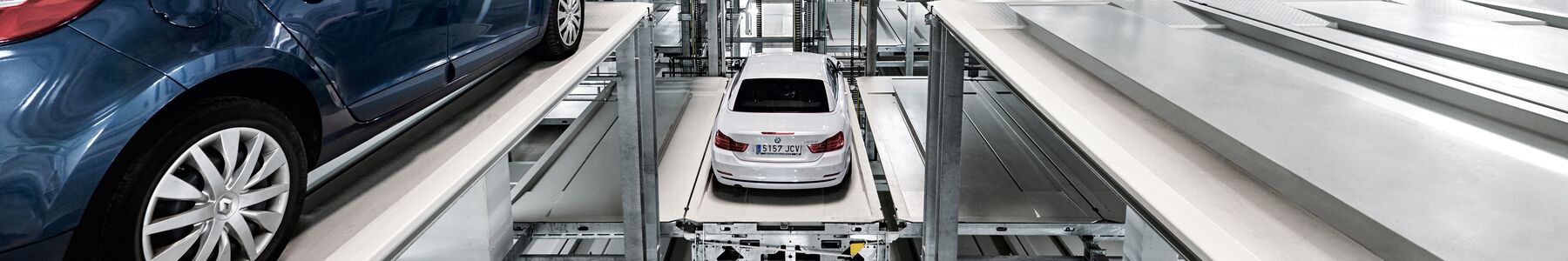 The car is parked on a parking pallet in a multi-storey car park system