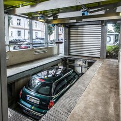 El coche se encuentra en una cabina de entrada sobre una plataforma de aparcamiento y desciende