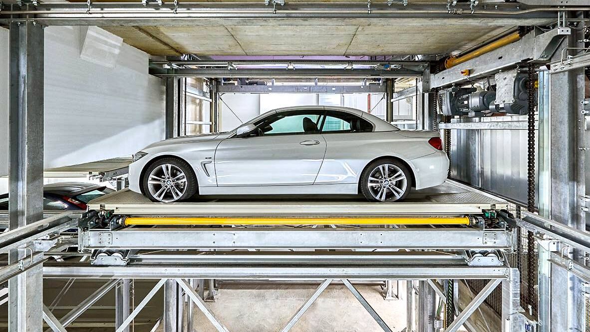 El coche se encuentra sobre una plataforma de estacionamiento en un sistema de aparcamiento
