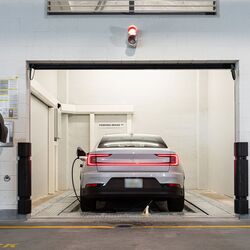 La imagen muestra la zona de entrega de un sistema de aparcamiento automatizado, donde el conductor inicia el proceso de estacionamiento para que el vehículo sea transportado y aparcado automáticamente dentro del sistema.