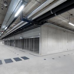 Modern underground parking garage with an intersection area, continuous driving lanes, and parking systems arranged on both sides.