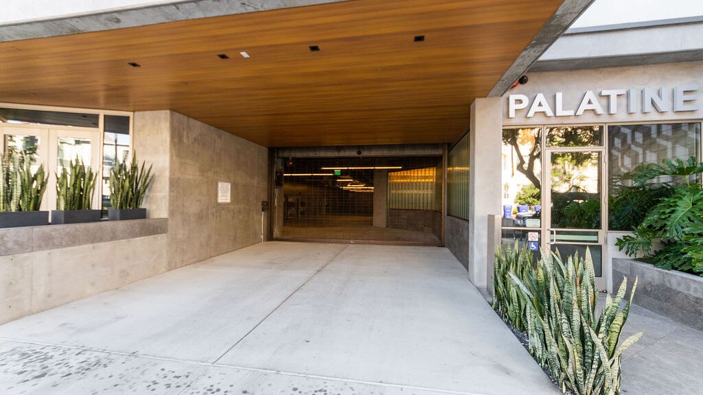 Entrada moderna a un edificio residencial con sistema de aparcamiento integrado.