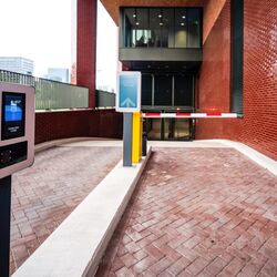Entrance to a modern parking system with an access terminal, digital guidance system, and automatic barrier.