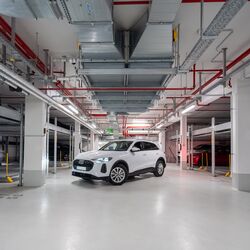 El coche está aparcado en el pasillo del aparcamiento subterráneo, entre dos sistemas Combilift