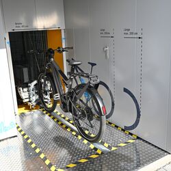 Bicicleta sobre un riel delante de un sistema automático de aparcamiento de bicicletas