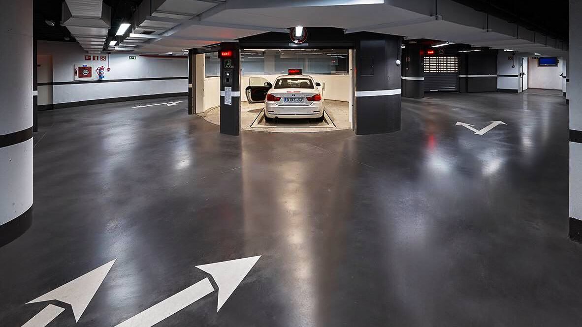 El coche se encuentra en una cabina de entrada, sobre una plataforma de aparcamiento