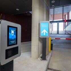 Exit from a modern parking system with an access terminal, digital driver information system, and automatic barrier.