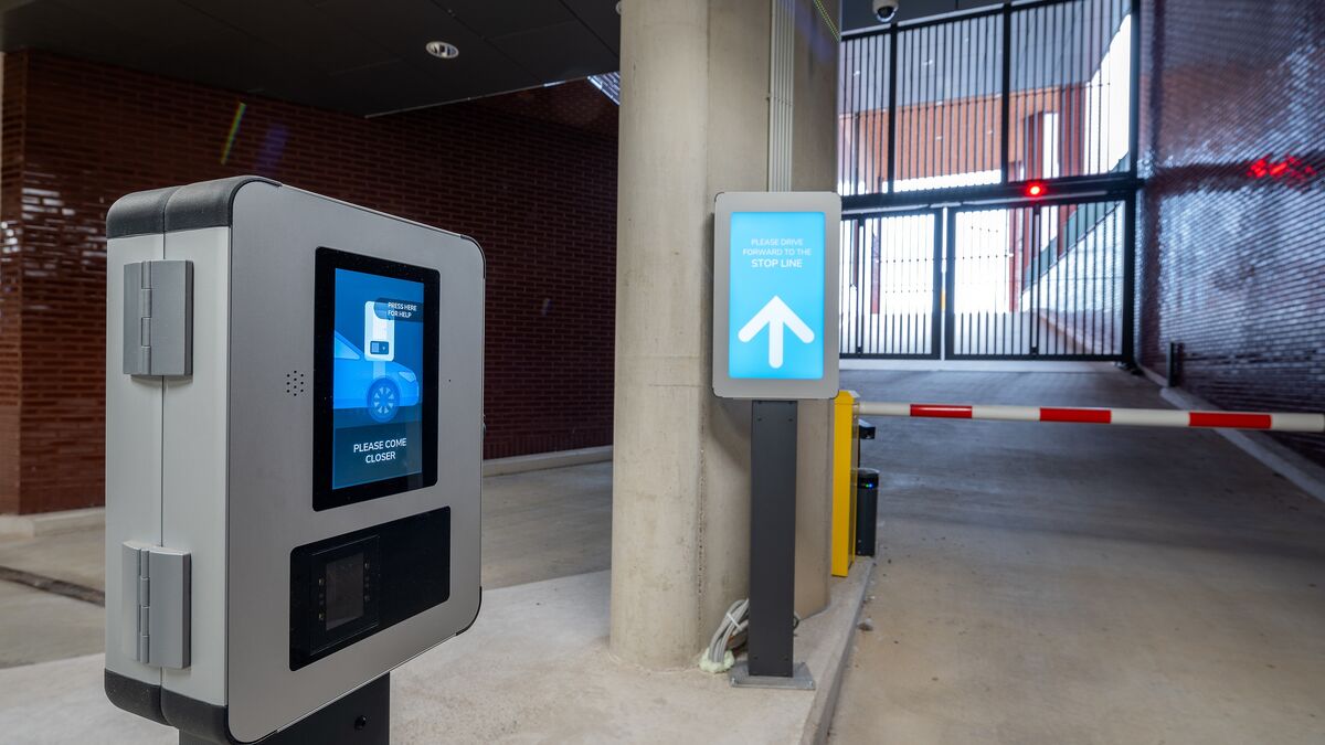 Exit from a modern parking system with an access terminal, digital driver information system, and automatic barrier.